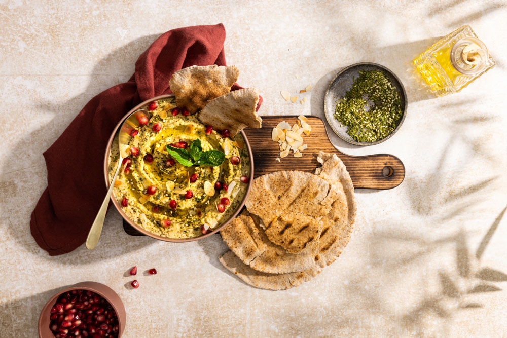 Hummus met za’atar, amandelschaafsel en granaatappelpitten