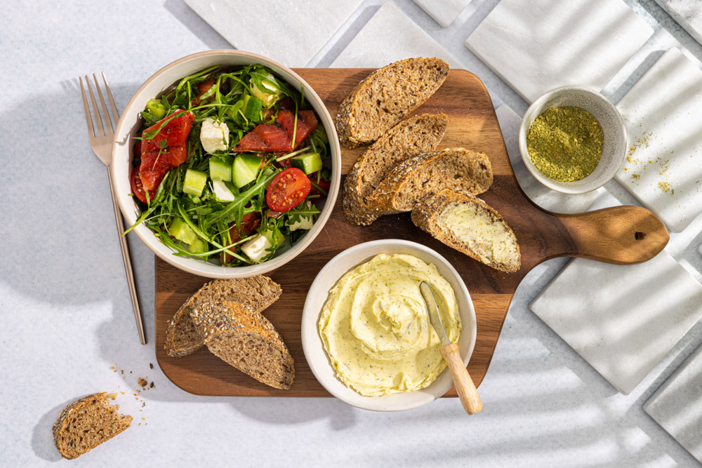 Kruidenboter geserveerd met een zomerse salade en robuust stokbrood